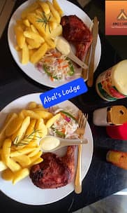 Two plates of fried chicken with chips and coleslaw